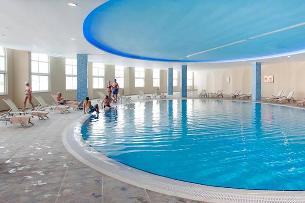 Hallenbad im Defne Defnem Hotel mit blauer Decke und blauem Wasser.