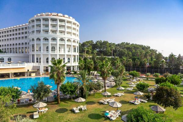 Defne Defnem Hotel Außenbereich mit Swimmingpool, Liegestühlen und Palmen.