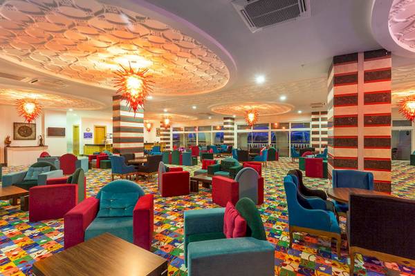 Lobby des Defne Defnem Hotels mit bunten Stühlen und Tischen.