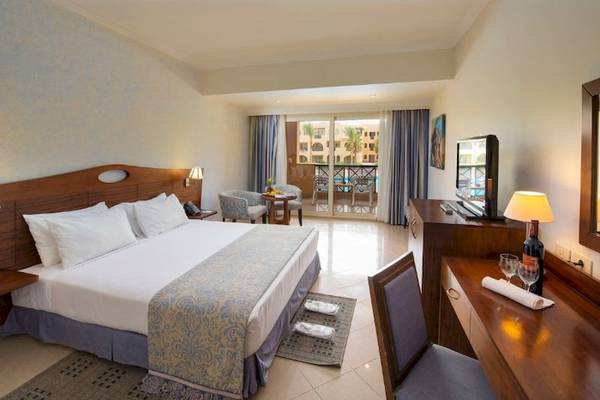Doppelzimmer im Stella Gardens Resort & Spa Makadi Bay mit Balkon, Bett, Schreibtisch, Fernseher und Balkonzugang