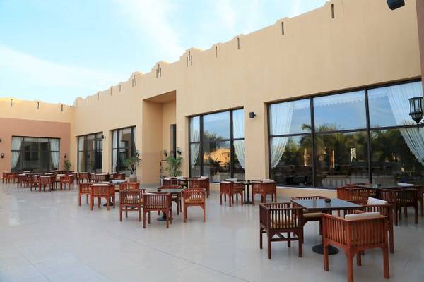 Terrasse mit Tischen und Stühlen im Stella Gardens Resort & Spa Makadi Bay