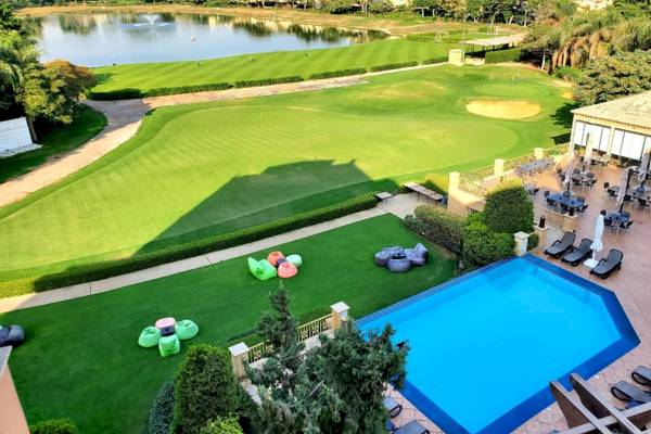 Luftaufnahme des Stella Gardens Resort & Spa Golfplatzes mit Außenbereich, Pool und Sonnenliegen.