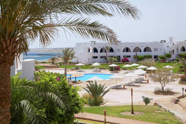 Außenbereich des Three Corners Equinox Beach Resorts mit Pool und Liegen.