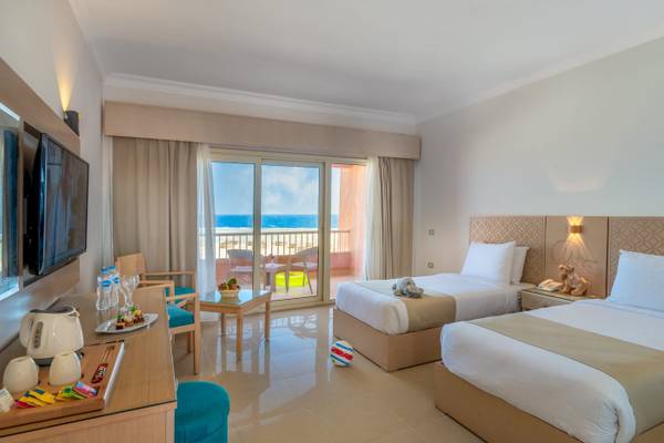 Zimmer mit Meerblick, zwei Betten, Tisch mit Frühstück und Balkon