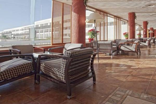 Hotellobby-Lounge mit gemusterten Stühlen, Lampen und einer Aussicht auf das Meer.