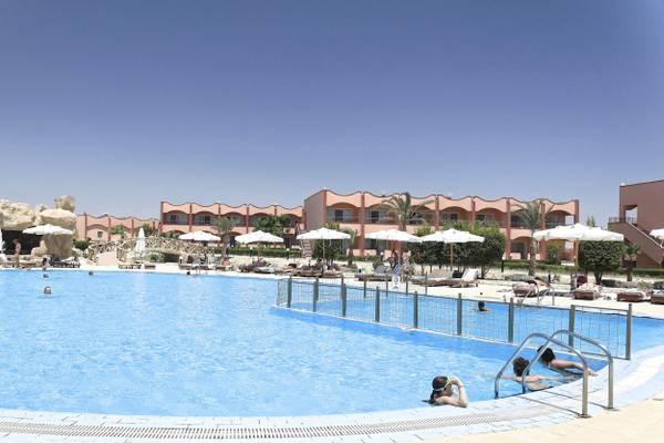 Ein Swimmingpool mit mehreren Schwimmern und Sonnenschirmen im Three Corners Happy Life Beach Resort.