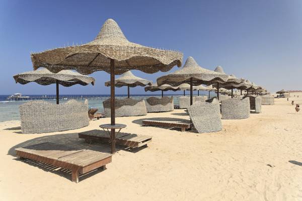 Strand mit Sonnenschirmen und Liegen im Three Corners Happy Life Beach Resort.