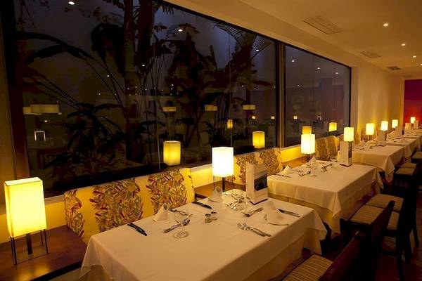 Innenansicht des Restaurants im Costa Calero Thalasso & Spa Hotel bei Nacht mit gedeckten Tischen und warmem Licht.