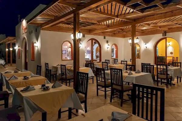 Innenansicht des Restaurants im Gorgonia Beach Resort mit gedeckten Tischen und Holzdecken.