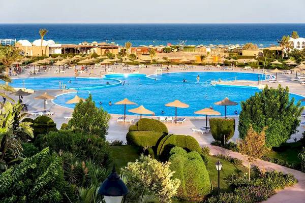 Aussenpool des Gorgonia Beach Resorts mit vielen Sonnenschirmen und Liegen.
