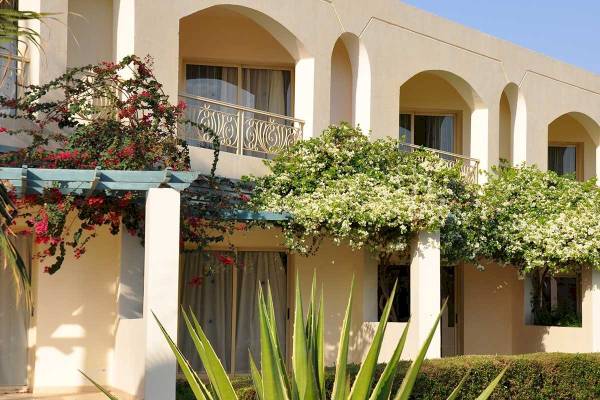 Außenansicht des Brayka Bay Resorts mit blühenden Pflanzen und architektonischen Elementen.