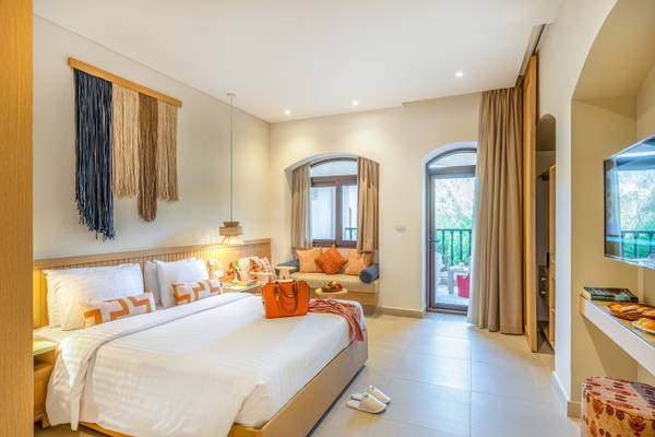 Drei-Ecken-Rihana-Resort-Zimmer mit großem Bett, Balkon und modernem Interieur.
