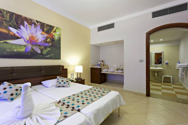 Doppelzimmerbett im Three Corners Rihana Resort mit Dekor und Badezimmerzugang