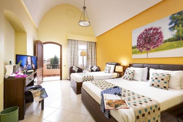 Doppelzimmer im Three Corners Rihana Resort mit zwei Betten und Balkonzugang.