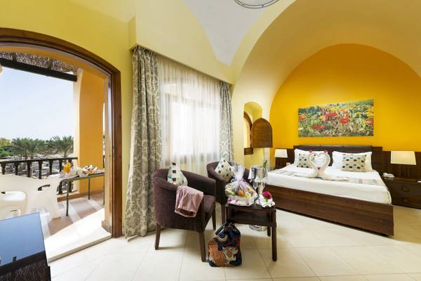 Innenansicht eines Hotelzimmers im Three Corners Rihana Resort mit Bett, Sesseln und Balkon