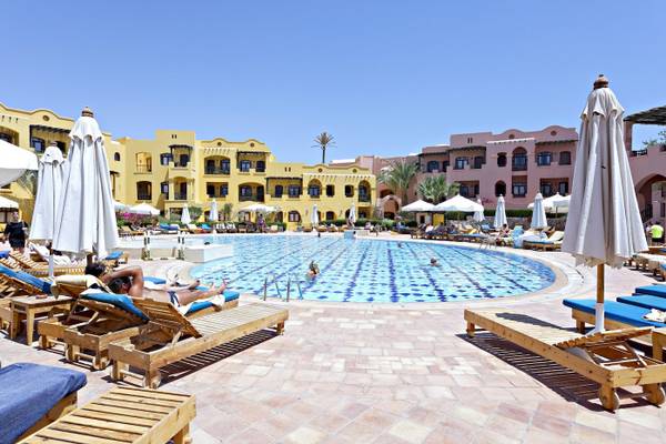 Swimmingpool im Three Corners Rihana Resort mit Sonnenliegen und Sonnenschirmen.
