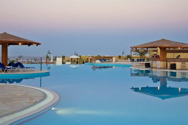 Ein Swimmingpool des Three Corners Fayrouz Plaza Beach Resorts bei Sonnenuntergang.