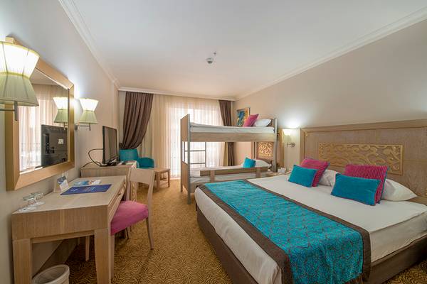 Doppelzimmer mit Doppelbett und Etagenbett, Schreibtisch, Spiegel und Fernseher.