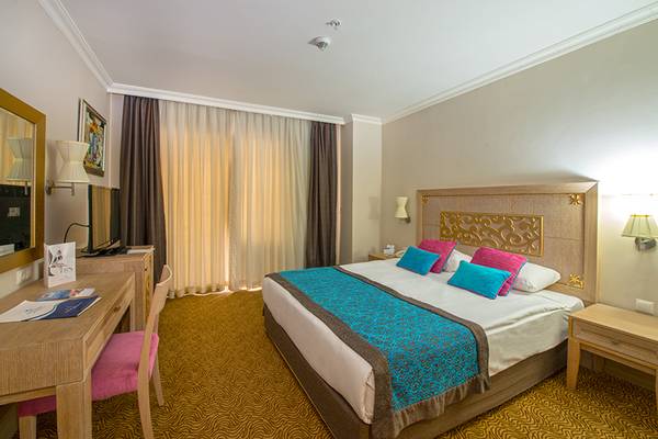 Ein Hotelzimmer im Crystal Family Resort & Spa mit einem Doppelbett, Schreibtisch und Stuhl.