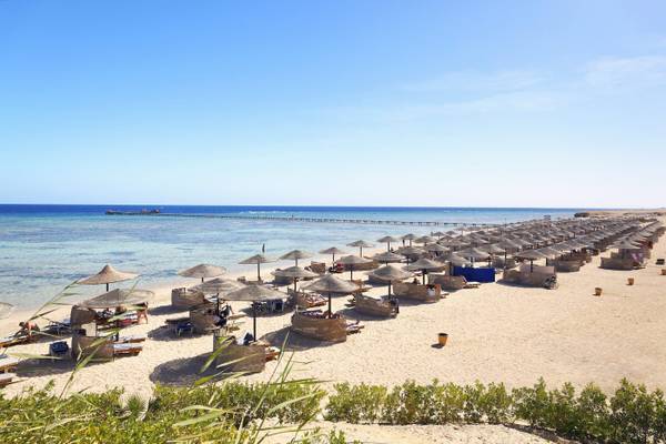 Drei-Ecken-Fayrouz-Plaza-Strandresort mit vielen Liegen und Sonnenschirmen am Strand