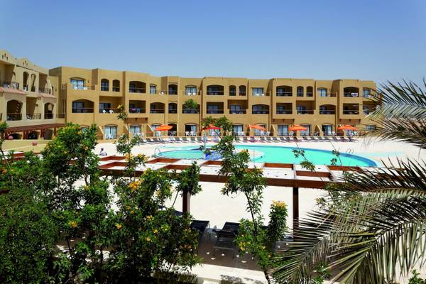 Außenbereich des Three Corners Fayrouz Plaza Beach Resorts mit Swimmingpool und Sonnenschirmen.