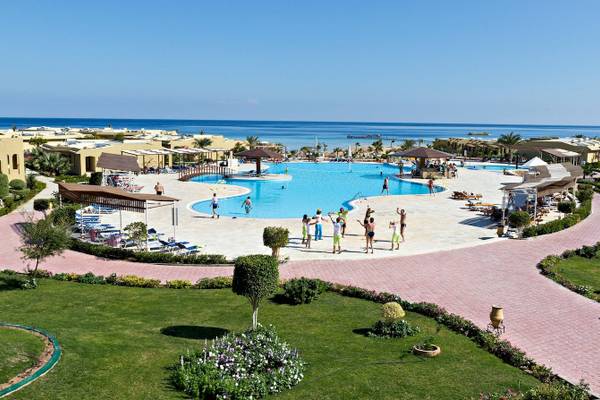 Luftaufnahme des Swimmingpools im Three Corners Fayrouz Plaza Beach Resort mit Gästen, Sonnenliegen und Palmen.