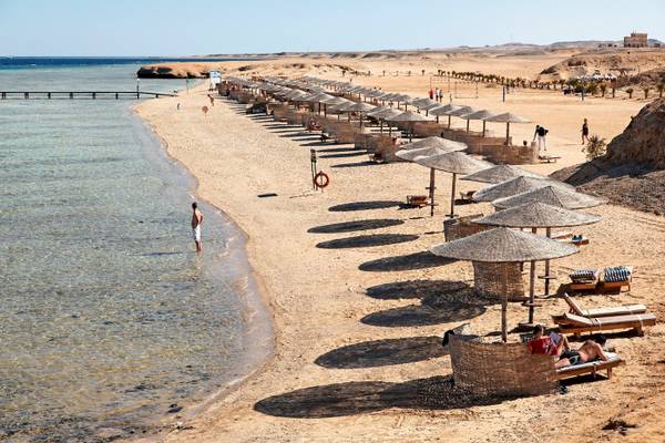 Drei-Ecken-Fayrouz-Plaza-Strandresort mit vielen Sonnenschirmen und Liegen am Strand