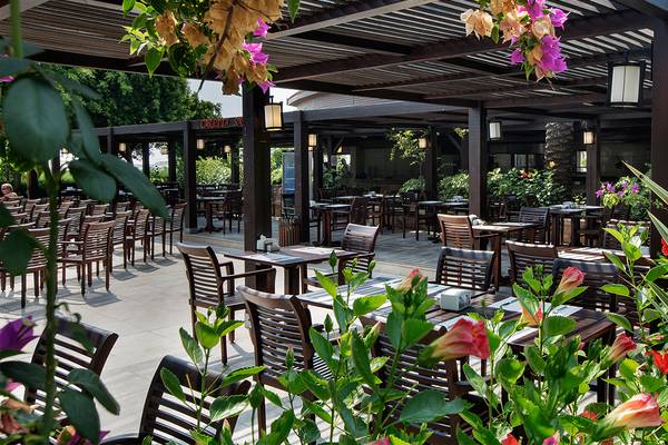 Außenbereich des Crystal Family Resort & Spa Restaurants mit gedeckten Tischen und Stühlen unter einer überdachten Pergola.