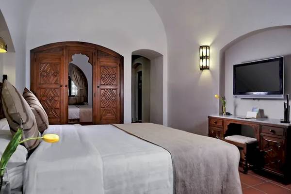 Schlafzimmer im Mövenpick Resort Sharm el Sheikh mit einem Bett, einem Fernseher und einem Schreibtisch.