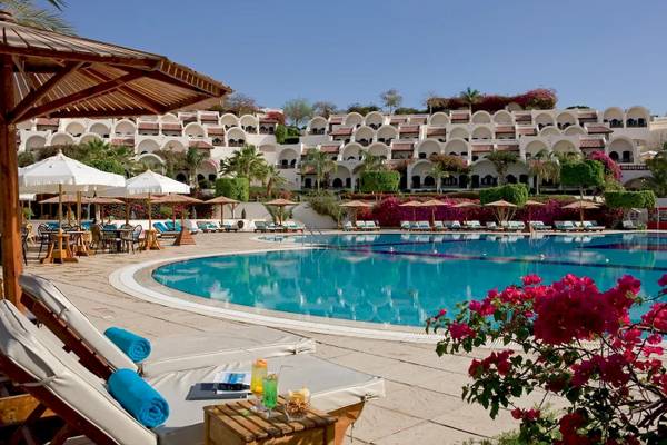 Außenpool des Mövenpick Resort Sharm el Sheikh mit Loungeliegen und Sonnenschirmen