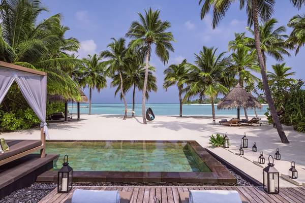 Außenpool des One & Only Reethi Rah Hotels mit Hängekorb und Laternen auf dem weißen Sandstrand.