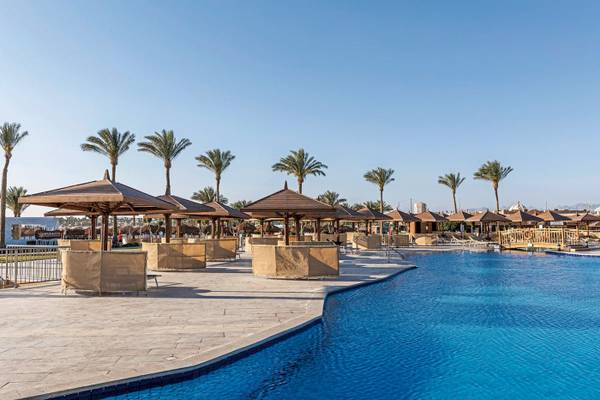 Poolbereich des Sunrise Royal Makadi Resorts mit Palmen und Sonnenschirmen