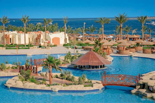 Pool im Sunrise Royal Makadi Resort mit Brücke und Palmen, Blick auf das Meer