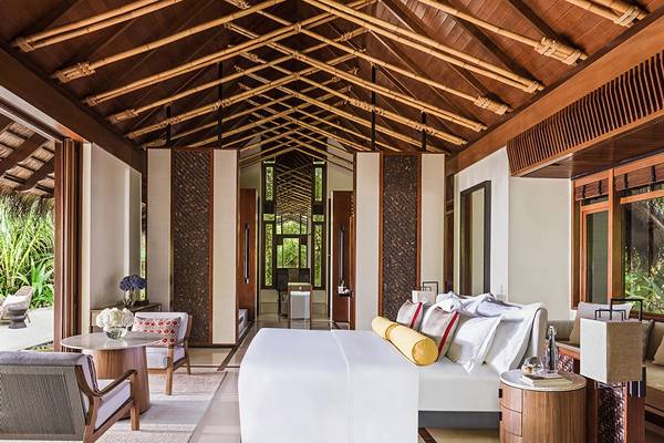 Ein Hotelzimmer im One & Only Reethi Rah mit einer großen Bett, Möbeln und Pflanzen draußen