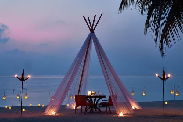Ein romantisches Abendessen unter einem beleuchteten Zelt auf dem Strand im One & Only Reethi Rah.