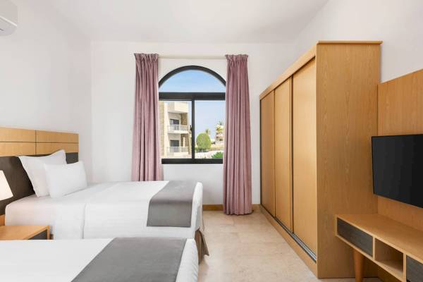 Hotelzimmer im Wyndham Garden Salalah Mirbat mit zwei Betten und Aussichtsfenster.