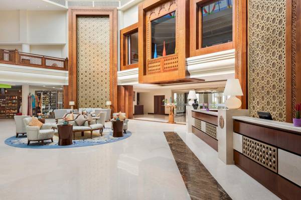 Empfangsbereich des Wyndham Garden Salalah Mirbat Hotels mit Loungemöbeln und Holzdekoration.