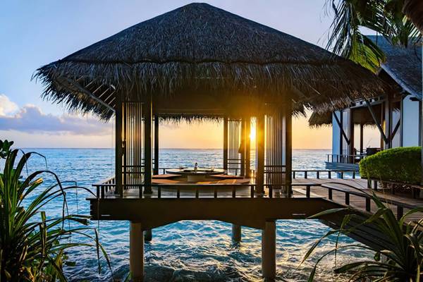Sonnenuntergang über dem Meer mit Pavillon auf Reethi Rah