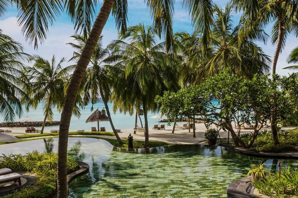 Außenpool des One & Only Reethi Rah Hotels mit Blick auf Palmen und Strand