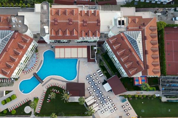 Außenansicht des Monachus Hotel & Spa mit Swimmingpool und Liegebereich.