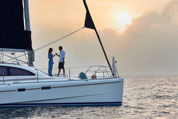 Paar auf einem Boot bei Sonnenuntergang im Meer