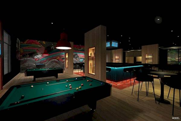 Poolhalle des RIU Atoll Hotels mit bunter Wand, Billardtischen und Sitzgelegenheiten.
