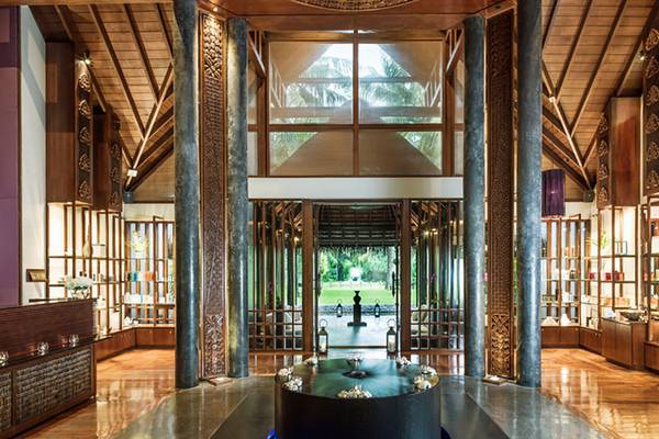 Innenbereich des One & Only Reethi Rah Hotels mit zentralem Brunnen und offenen Türen.