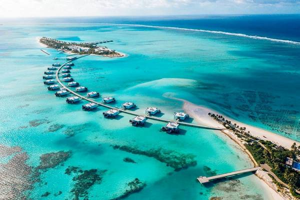 Luftaufnahme des RIU Atoll Hotels mit Wasservillen und türkisfarbenem Wasser