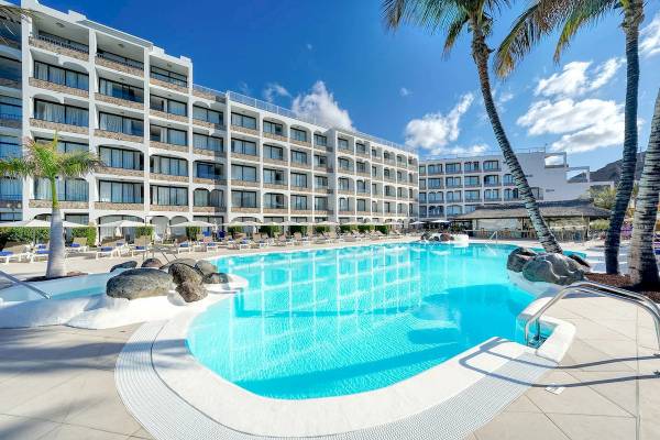 Außenpoolbereich des H10 Costa Mogan Hotels mit vielen Liegestühlen und Palmen