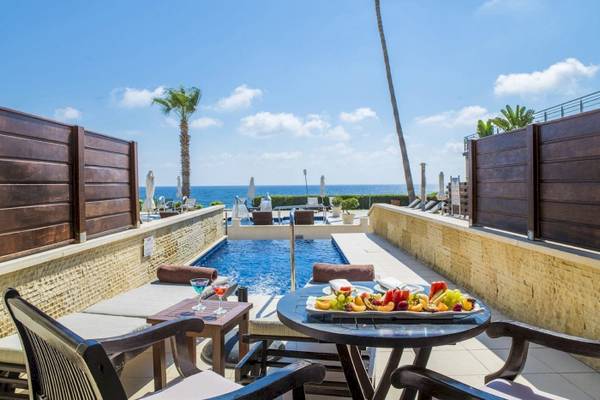 Terrasse im Alexander The Great Hotel mit Pool und Meerblick.