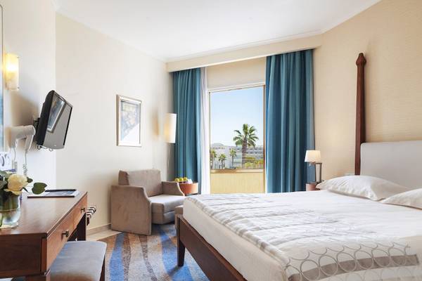 Hotelzimmer des Alexander The Great mit Bett, Schreibtisch, Stuhl und Ausblick