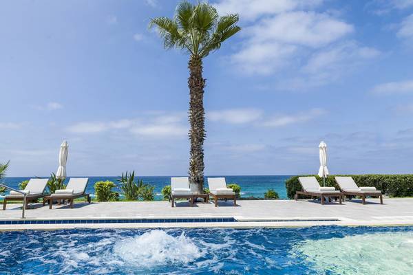 Alexander The Great Hotel Pool mit Lounge-Sesseln und Palme