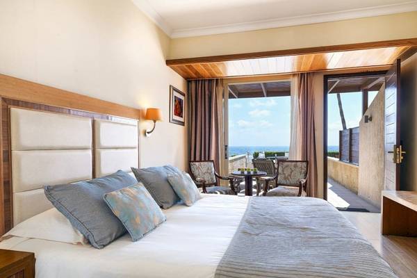 Zimmer im Alexander The Great Hotel mit Blick auf das Meer und Balkon.