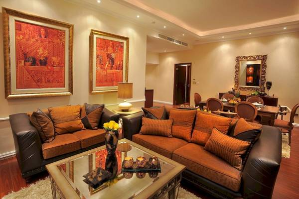 Wohnzimmer im Alexander The Great Hotel mit zwei Sofas, Tisch, Bildern und Dekor.